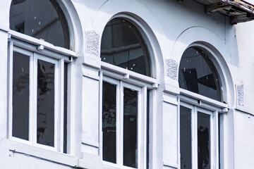 line of white vintage and old window with the circle shape on the white colonial heritage building architecture
