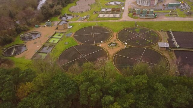 Sewage wastewater treatment plant into forest at Thetford, Norfolk - aerial timelapse drone circling flight shot