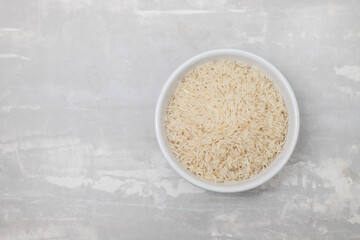 Fototapeta na wymiar raw rice on white bowl on gray ceramic