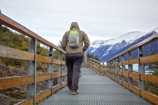 Young man, guy walks at Perito Moreno glacier in Patagonia. Floe located in Los Glaciares National Park, in the southwest of the Argentine province of Santa Cruz, El Calafate