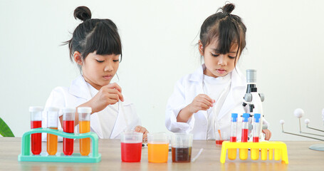 Little girl asian cute little student child learning research and doing a chemical experiment while...