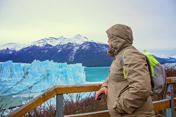 Fototapeta na wymiar A man, a tourist admires at the reserve in Perito Moreno, a glacier in Patagonia. Ice blocks in El Calafate, Argentina, Los Glaciares National Park