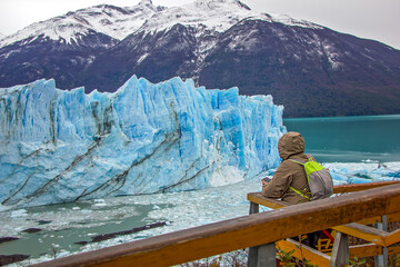 Young man, guy looks at Perito Moreno glacier in Patagonia. Floe located in Los Glaciares National...