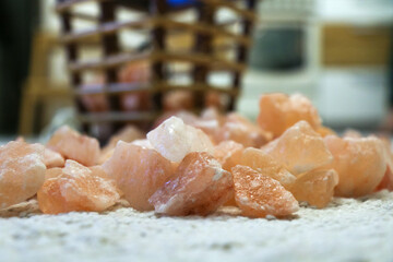 Himalayan salt lamp on table in design appartments. Wicker bamboo luminous lit lamp with pink salt crystals.