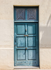 Antique blue and green painted wooden door with glass windows. Entrance to the building.