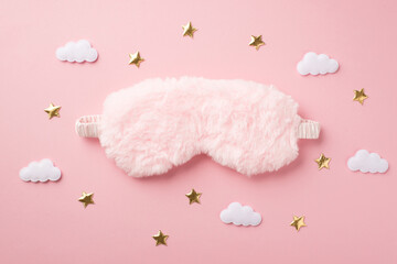 Top view photo of pink fluffy sleeping mask clouds and golden stars on isolated pastel pink background with empty space