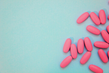 Pills and capsules spilling on blue background. Medicine concept of pain, depression, treatment.