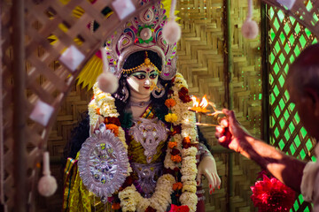 saraswati puja festival rituals being performed by priest. idol of hindu goddess saraswati in...
