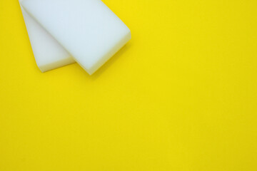Melamine sponges on a bright yellow  background. The concept of home cleanliness and cleaning.