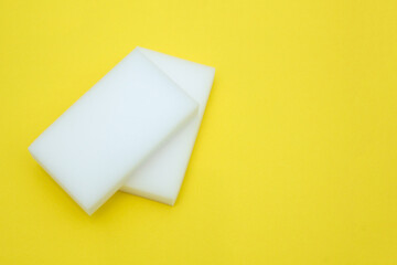 Melamine sponge for cleaning on a yellow background. The concept of cleanliness and detergents