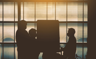 Blurred silhouette of business people meeting and brainstorming with flip chart at corporate office workshop.