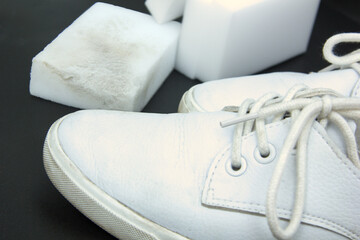 Melamine sponge and white sneakers on a bright background. Purity concept