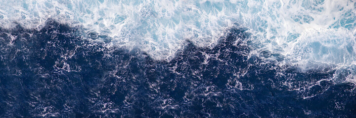 Background, banner for advertising. Raging sea with foam on the crest of a wave. Blue water background