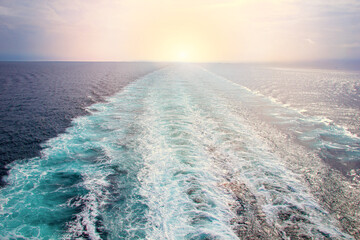 Trail from a liner on the surface of the sea at sunset.