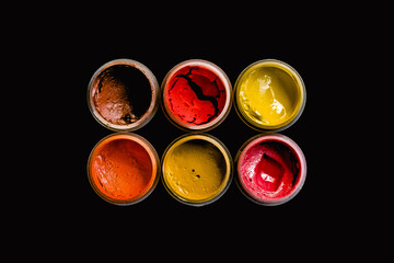 Dried gouache paints in red colors isolated on black background