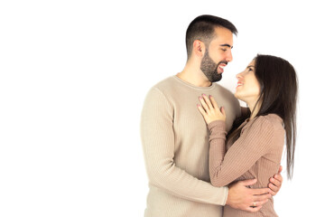 Young couple looking at each other while smiling on a white background