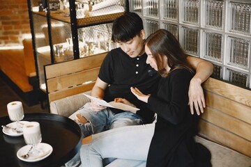 Young couple looking in menu to order dinner in restaurant