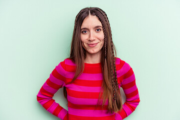 Obraz premium Young caucasian woman isolated on green background happy, smiling and cheerful.