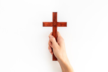 Christian wooden cross in hands. Faith and prayer concept