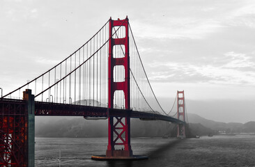 Monochrome Golden Gate Bridge in red, back and white in foggy background.