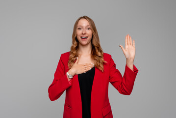 Smiling business woman introduce herself, raising hand and holding palm on heart, making promise,...