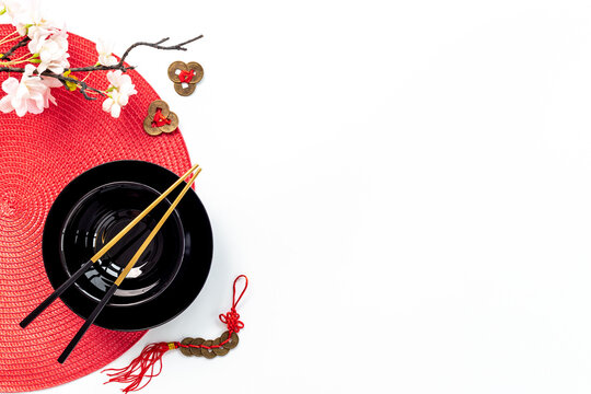 Asian tabble place setting with golden chopsticks on black bowl