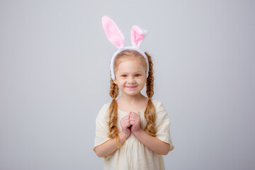 Obraz na płótnie Canvas cute little girl with bunny ears on a white background, portrait