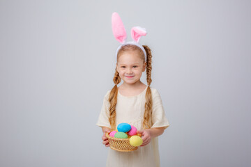 cute little girl with bunny ears easter egg basket on white background,