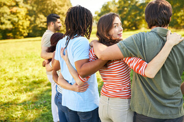 Gruppe junger Leute umarmen sich als Freunde