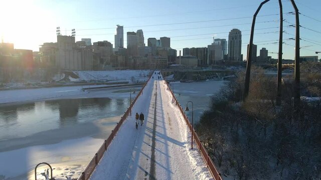People walking at Stone Arch bridge during a winter afternoon in Minneapolis