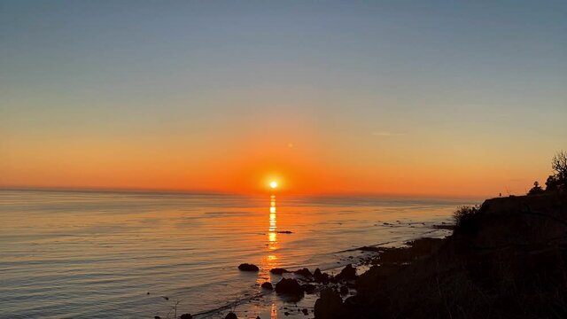Sun setting down over the ocean horizon at el Matador beach California time lapse
