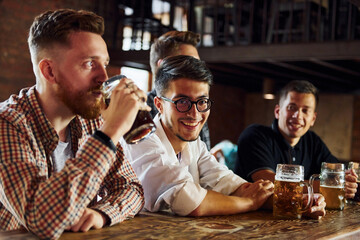 Positive friends. People in casual clothes sitting in the pub