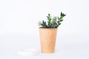 coffee cup of reusable materials with green twig on white background. zero waste concept. replacement for plastic cups