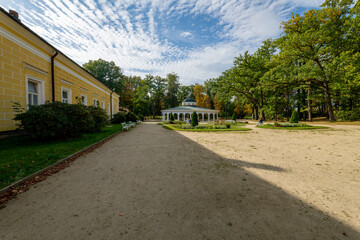 Obraz premium Spa park of Czech UNESCO city Frantiskovy Lazne (Franzensbad) - yellow building of Louise Spa (Spa I) and Empire Pavilion of Louise mineral water spring in autumn