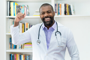 Cheering african american doctor with beard and stethoscope