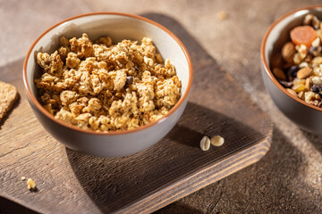 Healthy lifestyle breakfast, granola bowl on brown wooden table, cereal granola or organic seed muesli, horizontal