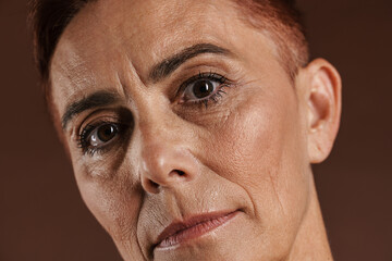Senior ginger woman with short hair posing and looking at camera