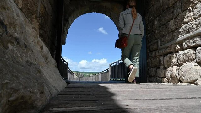 Video with a woman walks around the ruins of the old medieval fortress Ovech near Provadia, Bulgaria and enjoys the view from above. Low-angle view.