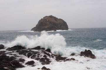 Fototapeta premium the sea hits the rocks and the islet hard