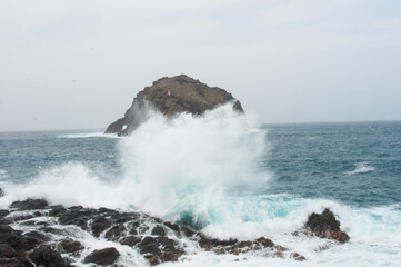 Fototapeta premium the sea hits the rocks and the islet hard