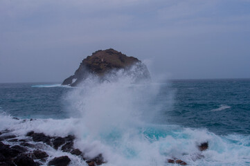the sea hits the rocks and the islet hard