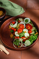 Vegetarian salad with cucumber, tomato and spinach in a plate