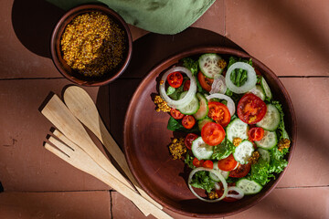 Vegetarian salad with cucumber, tomato and spinach in a plate