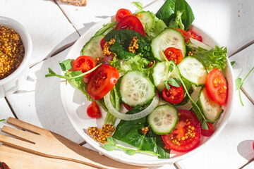 Vegetarian salad with cucumber, tomato and spinach in a plate