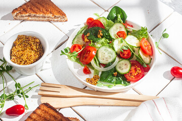 Vegetarian salad with cucumber, tomato and spinach in a plate