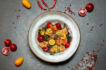 Salad with two types of salmon Baked salmon, smoked salmon, herb mix, cucumbers, sesame sauce, cherry tomatoes, kumquat, nori leaves