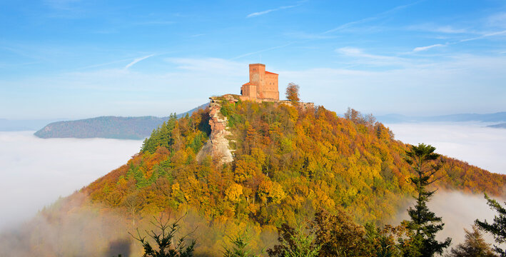 Sunny view of the castle Trifels in autumn above the fog