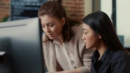 Team of software engineers talking about source code running on laptop screen while sitting at desk in it development office. Programmers collaborating on data coding group project.