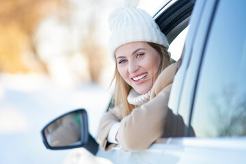 Happy woman driving car in snowy winter