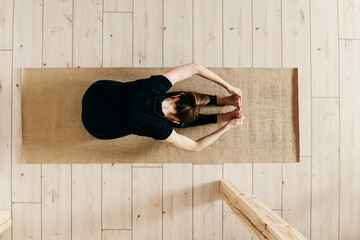 Top view of woman woman practicing yoga indoor.